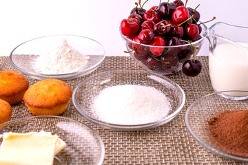  Ingredients for making homemade cupcakes with chocolate and cherries.