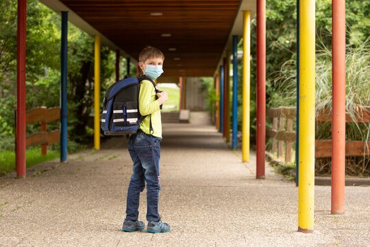 Kind auf dem Schulhof mit Mundschutz w&auml;hrend Corona