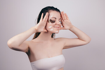 Fototapeta premium Young beautiful girl looking happy with eye patches on her face, problem dark circles under the eyes