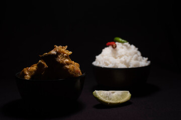Rice and chicken curry Bengali style dish in a black copy space background. Food photography.