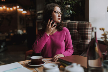 Young woman using smartphone in coffee house
