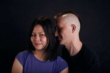 Portrait of mixed race couple in the studio. Two people together hug.