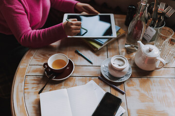 Young woman is working with tablet and smartphone in cafe