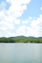 Fototapeta na wymiar Beautiful lake green trees with nice blue sky white clouds . 