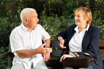 Elderly couple talking on bench