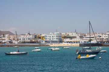 Corralejo Fuertaventura, Spain from the Harbor. Blue sea and sky with boats mored. Space left for copy text