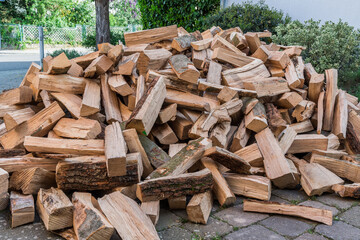 Unordentlicher Brennholzhaufen auf einem Laufwerk, geliefert für den Wintervorrat