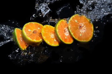 Fototapeta na wymiar Oranges cut into slices on the water surface