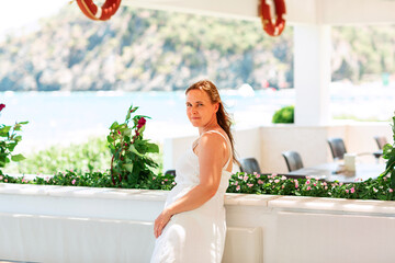Young woman relaxing on a terrace with the sea and mountain view