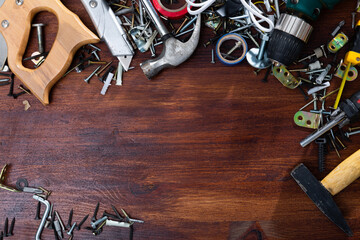 Various screws, bolts, tools on a wooden table. Space for text