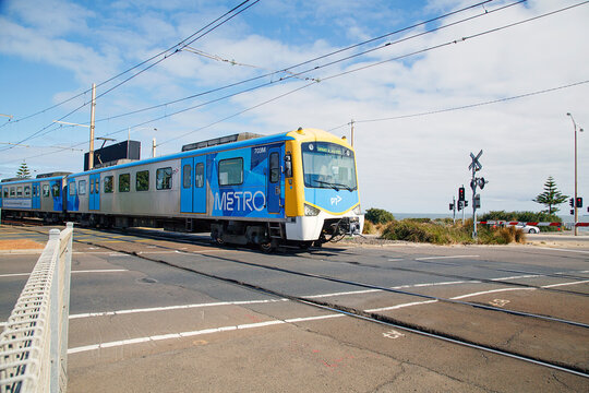 Melbourne, Australia: April 03, 2018: A train crosses the road as it arrives at Brighton Beach Railway Station which is located on the Sandringham line in Victoria, Australia.