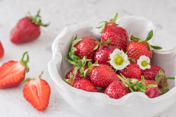 Handmade white pottery bowl with fresh strawberries on white background