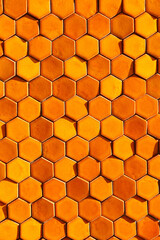 Bright orange sunlit hexagonal honeycomb tile background 