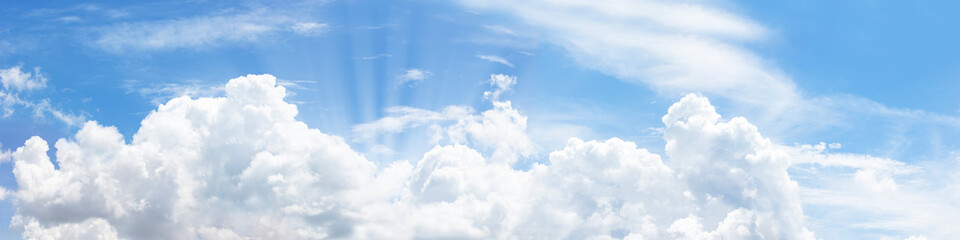 Naklejka na ściany i meble In sunny summer, huge clouds float on the blue sky.
