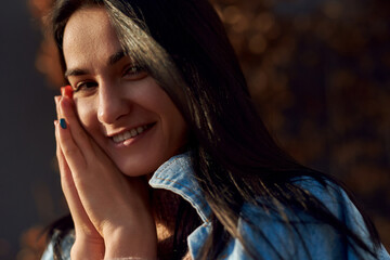 Pleased young lady keeping folded palms close to face