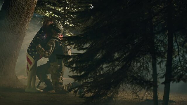 Young Girl With American Flag Hugging Her Kneeling Veteran Father Returning From Battlefield. 