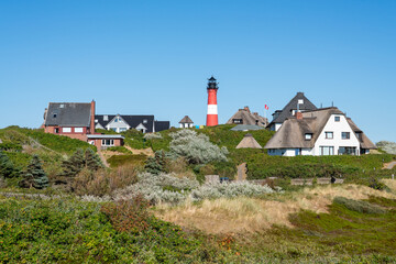 Fototapeta na wymiar Lighthouse Hörnum with traditional thatched roof houses, Sylt, Schleswig-Holstein, Germany