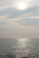 Natural background. The sun goes down to the horizon above the sea or ocean. Sunset over the water.