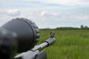 rifle with scope on the background of the field