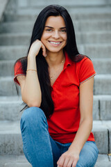 Close up of beautiful young smiling woman in red t-shirt enjoying drinking cola