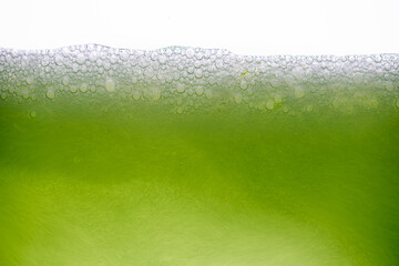 Background of close-up soda bubbles mixed with lemon juice or green juice on white background.