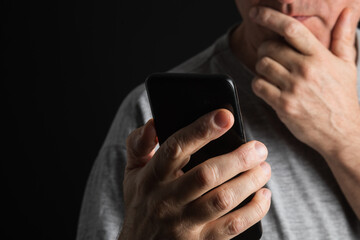 Man's hand holding smartphone, close-up.