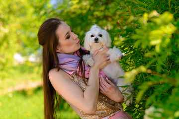 Young woman with her dog. Puppy white dog is running with it's owner. Concept about friendship, animal and freedom.