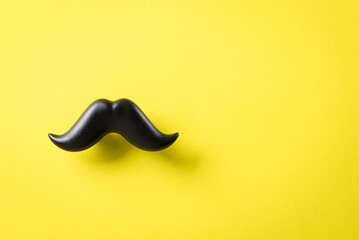 Father's day concept. Black moustache on yellow paper background.