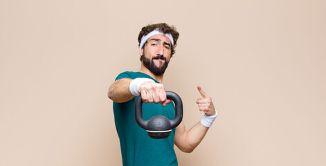 young cool bearded man at gym with a dumbbell. sport concept