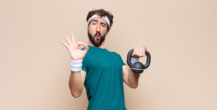 young cool bearded man at gym with a dumbbell. sport concept