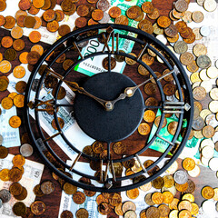 Time is money concept with iron wall clock, coins and banknotes