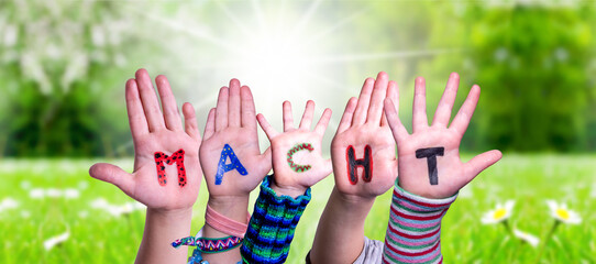 Children Hands Building Colorful German Word Macht Means Power. Sunny Green Grass Meadow As Background