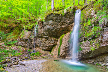Little waterfall with rocks and green forest near Gunzesried. Allgäu, Bavaria, Germany