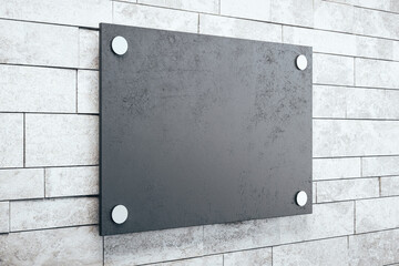 Side view of black glass plate on brick wall background.