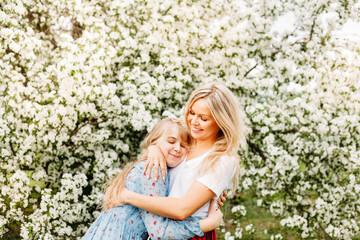 Mother and daughter in blooming trees, spring, Apple tree, flower, beauty, fashion, hugs, kisses