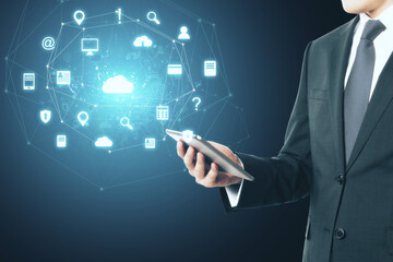 Businessman holding tablet with glowing social network icons.