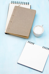 An open notebook on springs with white craft paper lies on a table. Concept for business ideas. Home office workplace. Flat lay, Business-finance or education concept