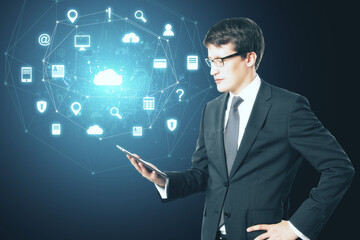 Businessman holding tablet with glowing social network icons.