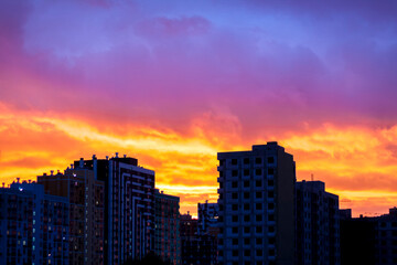 Fototapeta na wymiar Sunset in the city. Fire, a beautiful sunset over the houses of the city. Fire sky.