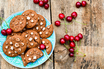    Fresh organic Cherryes and cocoa cookies with  vanilla star decoration on wooden background. Summer dessert
