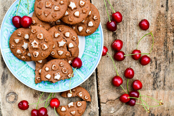    Fresh organic Cherries and cocoa cookies with  vanilla star decoration on wooden background. Summer dessert
