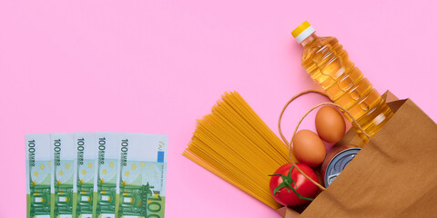 Paper bag set of pasta, canned food, eggs, tomatoes, sunflower oil and euro banknotes money, on...