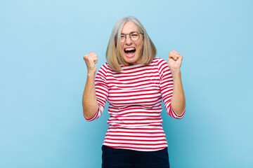 senior or middle age pretty woman shouting aggressively with annoyed, frustrated, angry look and...