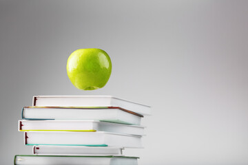 Apple green hanging over books isolate on a white background.