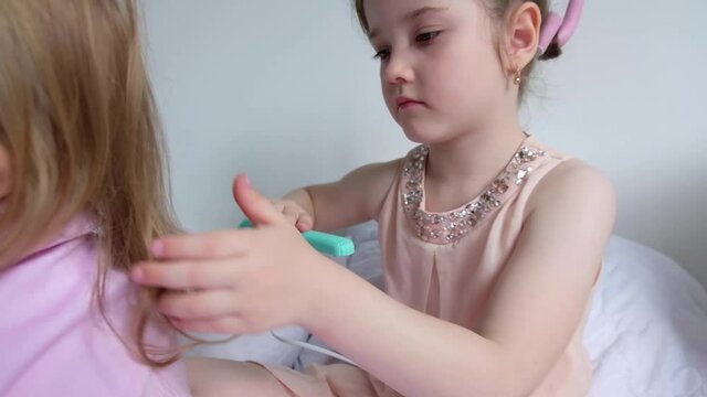 girls at home play in a beauty salon and do hairstyles