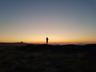 Fototapeta na wymiar Silhouette of a man standing on a hill on the sunset, Silhouette of a man on the sunset, Cappadocia, Kapadokya, Turkey, Uchisar Castle in Cappadocia Region of Turkey, Sunset, National Geographic