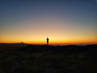 Fototapeta na wymiar Silhouette of a man standing on a hill, Silhouette of a man on the sunset, Cappadocia, Kapadokya, Turkey, Uchisar Castle in Cappadocia Region of Turkey, Sunset, National Geographic