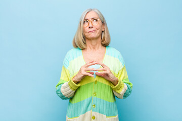 senior or middle age pretty woman scheming and conspiring, thinking devious tricks and cheats,...