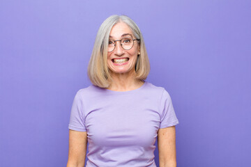 senior or middle age pretty woman looking happy and goofy with a broad, fun, loony smile and eyes wide open