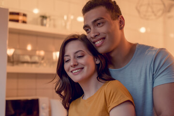 cheerful and multiracial couple smiling at home